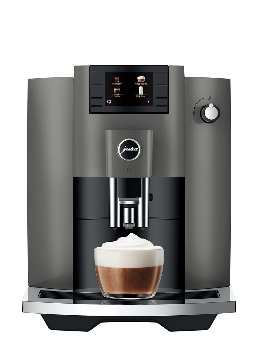 Jura E6 Dark Inox NAC espresso machine, front view showing the drip tray, control panel, and dispensed cappuccino in glass cup