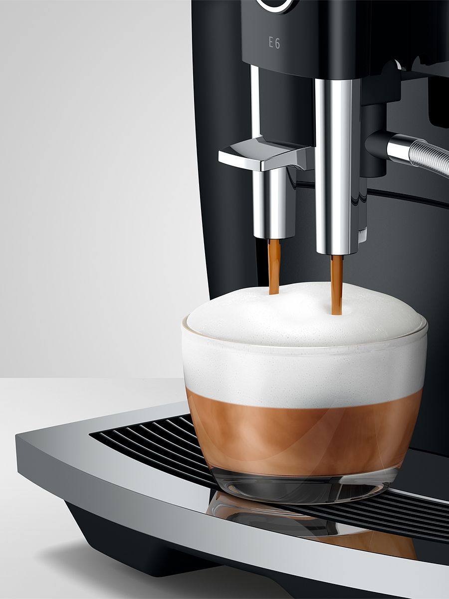 Close up or E6 Piano Black dispensing espresso into a cappuccino 