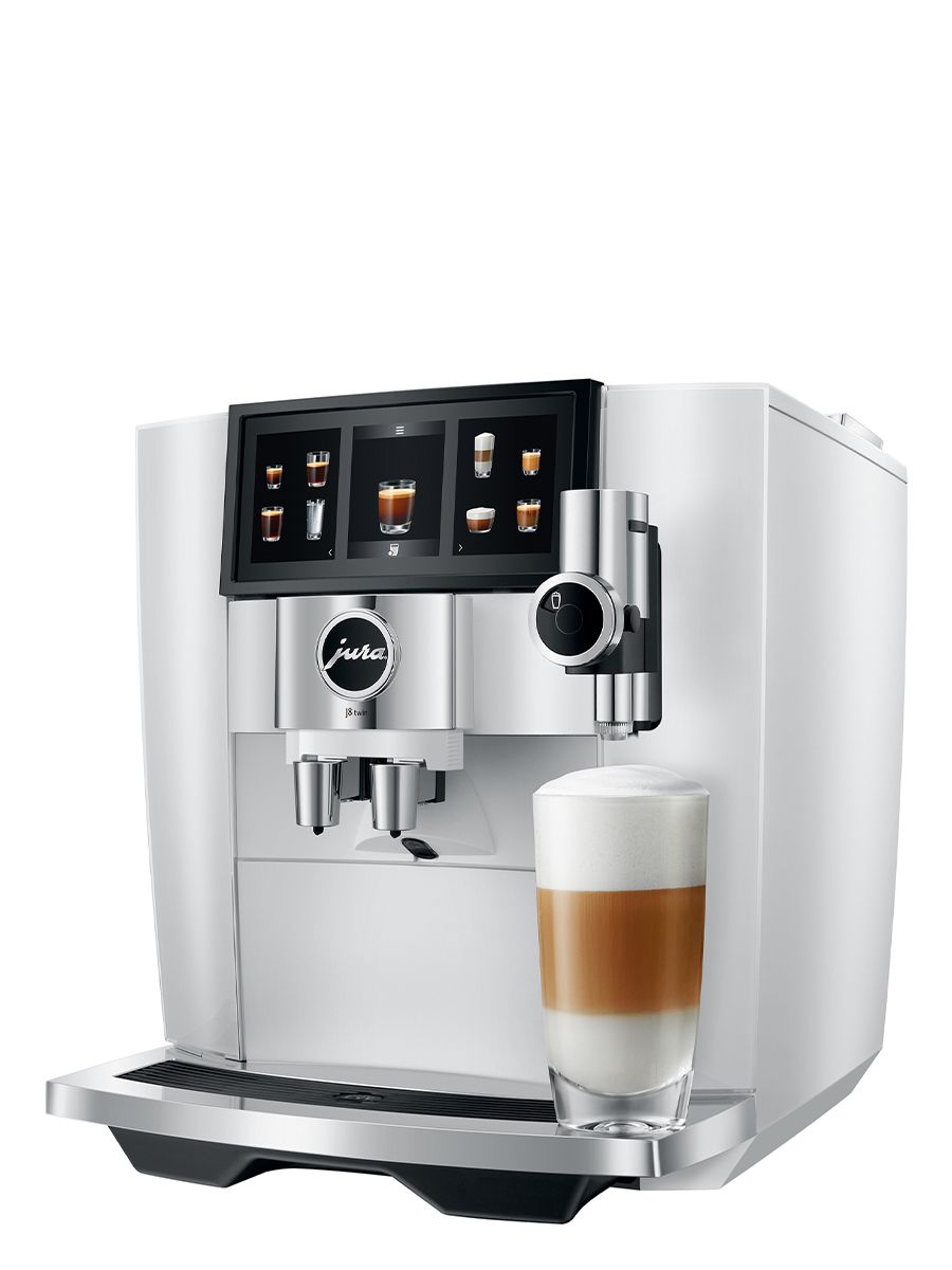 Left side view of J8 twin Diamond White featuring touchscreen display, drip tray, coffee spouts, with Latte Macchiato in a glass cup
