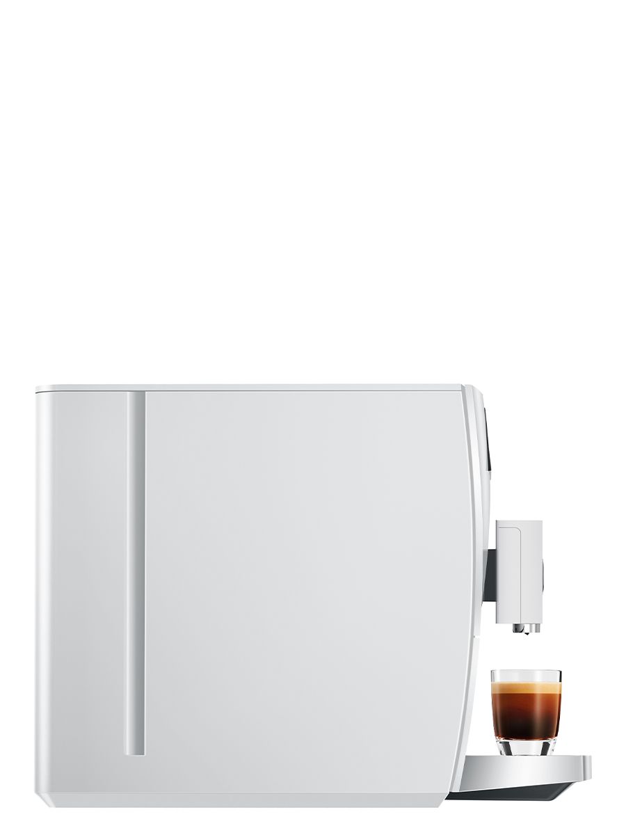 Side view of the JURA C3 Piano White coffee machine with a glass cup of espresso placed beneath the coffee spout.