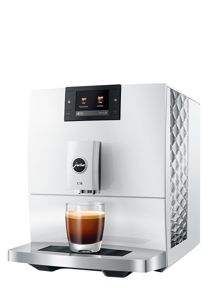 Angled front view of the JURA C9 Piano White coffee machine with a single espresso in a glass cup on the drip tray and textured side panel visible.